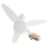 Fotografia de um Ventilador de Teto Inverter Silent na cor branca, com 3 pás de design aerodinâmico e luminária LED central. Uma mão aparece segurando o controle remoto branco, demonstrando a praticidade e modernidade do produto.